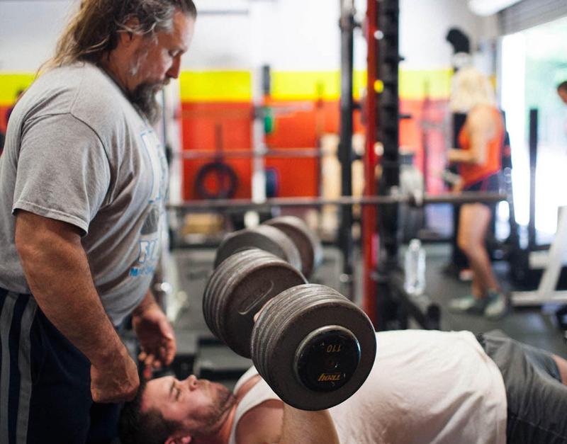 A Roswell Barbell coach spotting a bench press